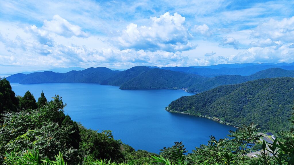 View from summit of Shizugatake - of a vivid blue lake surrounded by green mountains - Japan